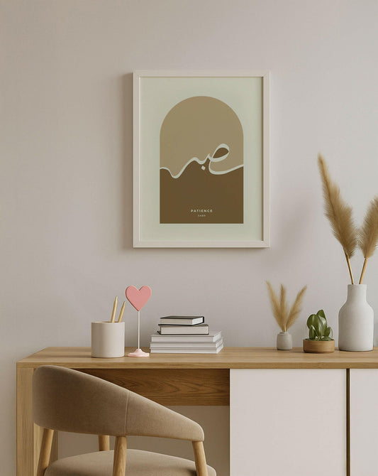 Minimalist home setup with a framed artwork, books, and decorative items on a wooden desk.